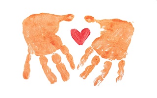 A pair of handprints surrounding a hand-painted heart symbol