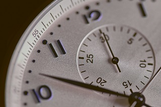 Close-up of an analogue watch face, with a second hand.