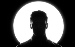 Silhouetted person in front of bright white light